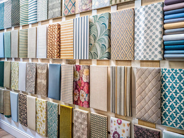 A display of various wallpaper sample swatches in different patterns and colors, highlighting their importance in home design selection.